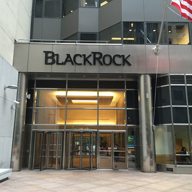 A blackrock building with an american flag in front of it.